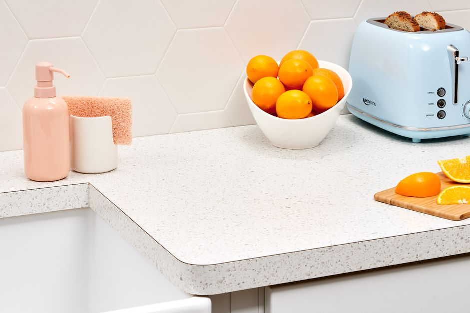 grey and white speckled kitchen counter with oranges and a toaster
