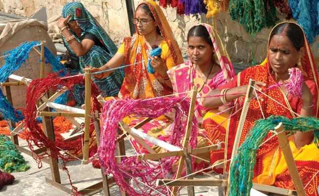 Rural women weaving colourful yarns