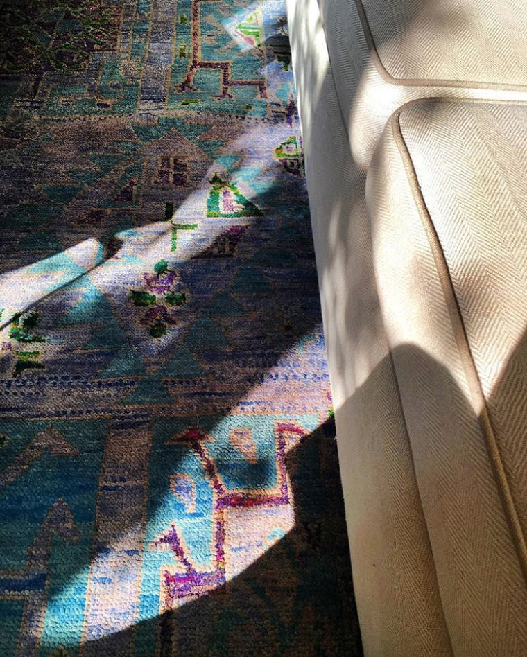 Close up of a colourful carpet next to a sofa